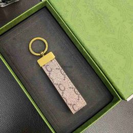 Porte-clés Porte-clés en cuir haut classique exquis luxe designer voiture porte-clés en alliage de zinc lettre unisexe lanière or noir métal petit cadeau de bijoux 240303