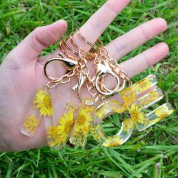 Keychains lanyards gele madeliefje Engelse sleutelhanger 26 letters mode zoete hangers accessoires schattige gedroogde bloemenwagen zakje slijtage ornamenten geschenken