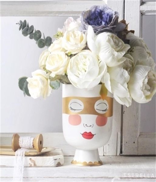 Petite fille tête mate table de fleur vase femme face visage doré masque oculaire arrangement flor