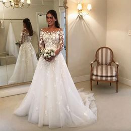 Manches longues Robes de mariée gracieuses Sheer Bateau Neck Lace Couverte Boutons Bridal Robes Sweep Train Tulle Robe de Marie