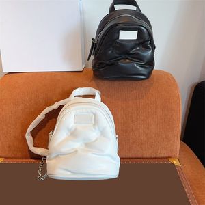 Léchard de couleur unie de couleur solide Logo Patch zipper pliant pliant en peau d'agneau joker nouveau sac à dos sac à dos dames classiques en noir et blanc.