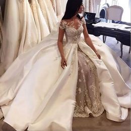 Robes de mariée de robe de bal de luxe 2024 Arabie Saoudite Cap Manches Dentelle Applique Satin Overskirt Robes de mariée sur mesure Robes de mariée de Dubaï