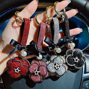 Porte-clés de voiture fleur de luxe anneau strass camélia arc pendentif porte-clés pour décoration de sac personnalisé mode femmes diamant breloques clé