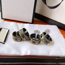 Diseñador de joyas de lujo Anillos de banda Mujer hombre Amor Encantos negros Suministros de boda Anillo de acero inoxidable chapado en oro de 18 quilates Anillo de dedo fino Sello en relieve Hombres anchos