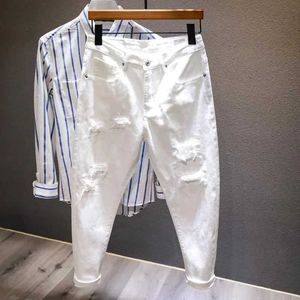 Herenjeans nieuwe witte jeans mannen all-match mode gescheurd gat slanke stretch harem broek comfortabele mannelijke strmar denim broek y240507