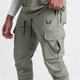 Pantalones de hombre con bolsillo Cargo de verano, mallas elásticas delgadas de secado rápido, pantalones de chándal de entrenamiento para correr, pantalones de tendencia informales