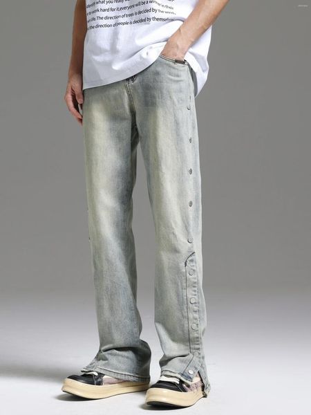 Le pantalon masculin lavé pour faire de vieux jeans à poitrine de boue jaune avec des fentes étire la jambe droite