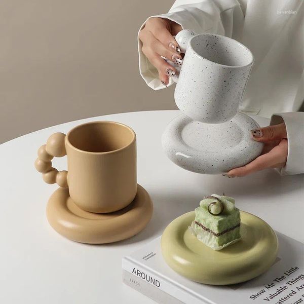 Tasses tasse de café en céramique nordique avec soucoupe à la main le pavé de gâteau à thé d'après-midi à la main.