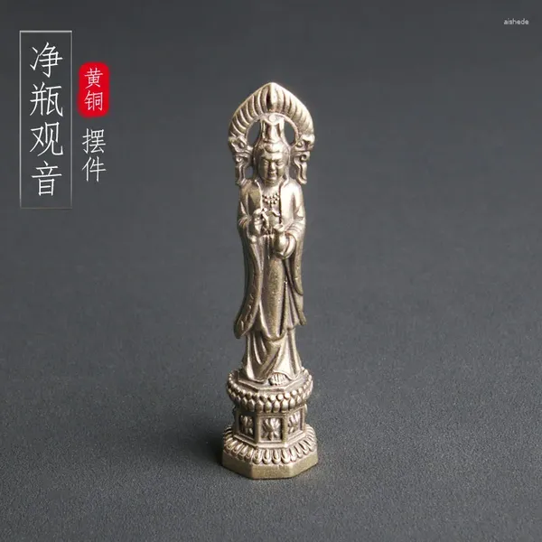 Des boucles d'oreilles de collier Régèrent la statue de Bouddha en laiton de Guanyin Bodhisattva dans une bouteille propre est consacrée sur la table comme divinité