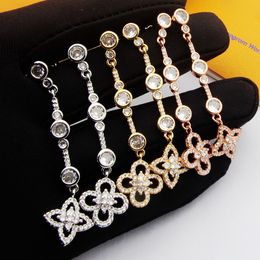 Nouveau conçu bijoux en acier titane V-lettre quatre feuilles fleur boucle d'oreille diamant complet bracelet collier de mode bijoux de créateur LV019100