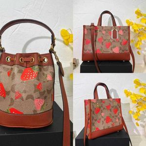 Nouveau produit COABAG Strawberry Drawstring Bags C Print Designer Sacs à bandoulière Femmes Élégant sac à main en cuir et sacs seau Grand sac de plage Fourre-tout Lady Purse