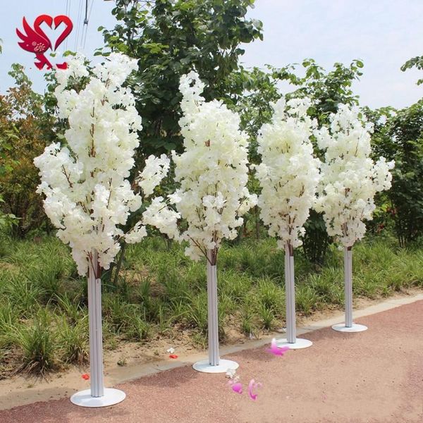 La route des cerisiers en fer de 1,5 m de haut en fleurs de cerisier mène à des étagères pour simuler des accessoires de mariage en fleurs de cerisier.