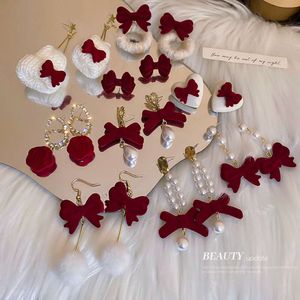 Red Veet Studded Pearl Bow Koreaans niche -ontwerp, gepersonaliseerde en eenvoudige oorbellen, veelzijdig voor vrouwen