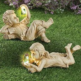 Statue de jardin en résine pot garçon fille un enfant avec des lucioles solaires brillent dans le parterre de fleurs fantaisiste sombre cour sculpture extérieure décor couché 240108