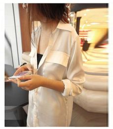 Mujer sexy con camisa blanca y secciones largas y camisa de gasa de manga larga suelta de doble bolsillo2372424