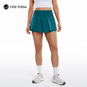 CRZ YOGA Short de sport fluide taille haute pour femme, jupe portefeuille à volants, doublure avant, short de course avec poche zippée