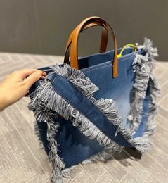 Sacs à bandoulière Automne et hiver 22 Nouveau sac à provisions en toile denim avec pompon Une épaule fourre-tout Messager portable Grande capacité femme