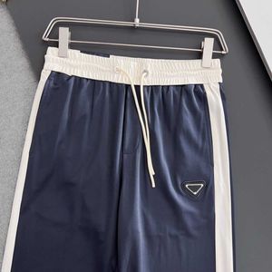 Los hombres de primavera y verano dibujan pantalones largos de piernas pequeñas casuales con corbata de cuerda, tela suave y cómoda, rayas de retazos de moda casual todo.