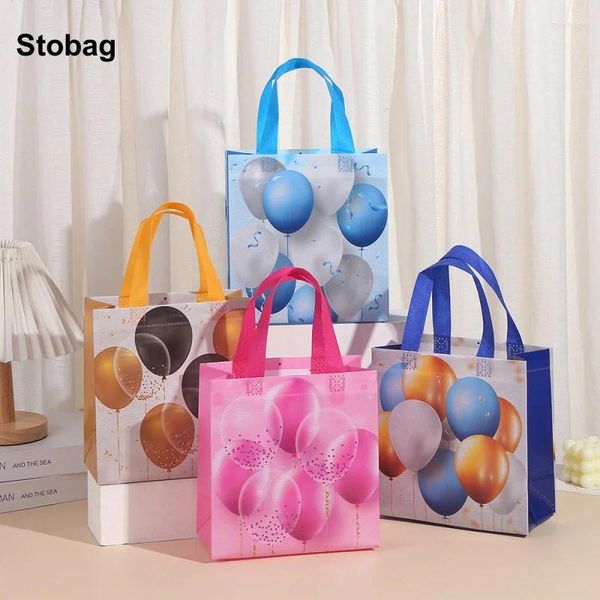 Bolsas de almacenamiento Stobag 12pcs globo de dibujos animados no tejidos bolsas de bolsas de regalo para niños paquete de tela impermeable favores de fiesta de cumpleaños reutilizables