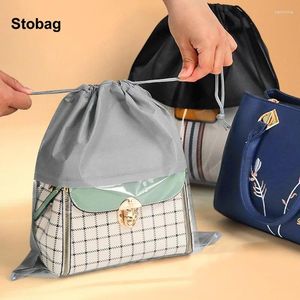 Sacs de rangement Stobag 25pcs Pagnières à cordon non tissées Sachets à poussière réutilisables avec le logo de l'organisateur de voyage de fenêtre transparent (frais supplémentaires)