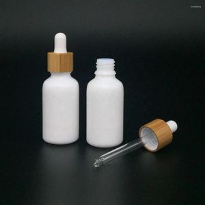 Bouteilles de rangement en gros de la peau personnalisée en porcelaine blanche bouteille de compte-gouttes à épaule rond avec des parfums d'huile essentielle de couvercle de couvercle en bambou