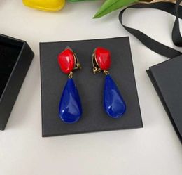 Pendientes de tuerca con forma de gota de agua, Clip para la oreja media con contraste de Color rojo y azul, accesorios tipo hebilla dorada de resina con personalidad moderna