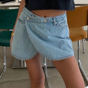 Couleur solide des femmes d'été Fashion sexy hautement épissé Pocket Rivet Short Diagonal Bouton Pantalon de jupe de jean en vrac 240407