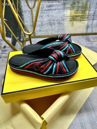 Les dernières chaussures à fond épaisses à fond plat en 2023 sont liées avec des sandales à attacher avec un matériau lafite tissé sur les détails supérieurs et brodés en bleu clair et rouge.