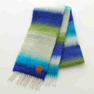 La nouvelle écharpe en laine mohair rayée est dotée de pompons aux deux extrémités, ce qui rend le tissu super confortable