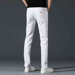 Dunne zomerjeans voor jonge mannen Koreaanse versie elastische slanke fit kleine voeten eenvoudige pure witte casual broek