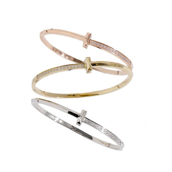 Tifaniym classic 04 La misma pulsera a presión asimétrica con media luz en forma de T y diamantes está hecha de acero de titanio disponible en tres colores para mujer.