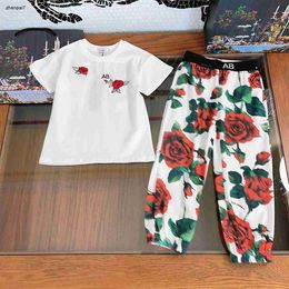 Top Girls Tracksuits Baby Twee-delige Set Kids Designer Kleding Maat 90-150 cm Rode bloemen en groene bladeren T-shirt en geruite broek 24mar