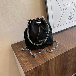 Polyvalent nouveau sac seau triangulaire en toile de nylon mini niche sac à main à double chaîne avec cordon de serrage pour femme