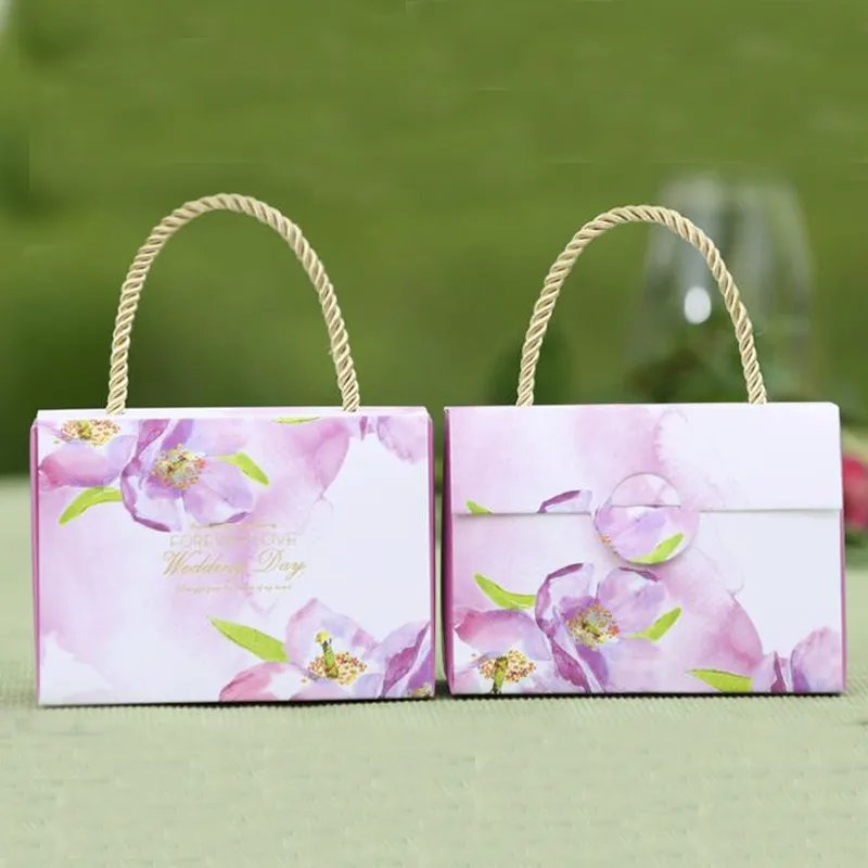 Niedliche Hochzeits-Geschenkbox im Handtaschen-Stil mit Griff. Schöne und pupulare Hochzeits-Party-Tasche für Süßigkeiten in den Farben Grün, Lila und Rot