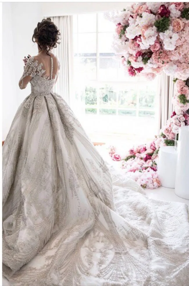 Abito da sposa glamour in pizzo con scollo a barchetta Abito da sposa con collo gioiello trasparente Maniche lunghe Perline con perline Abito da sposa con applique Affascinante abiti da sposa con strascico da cappella