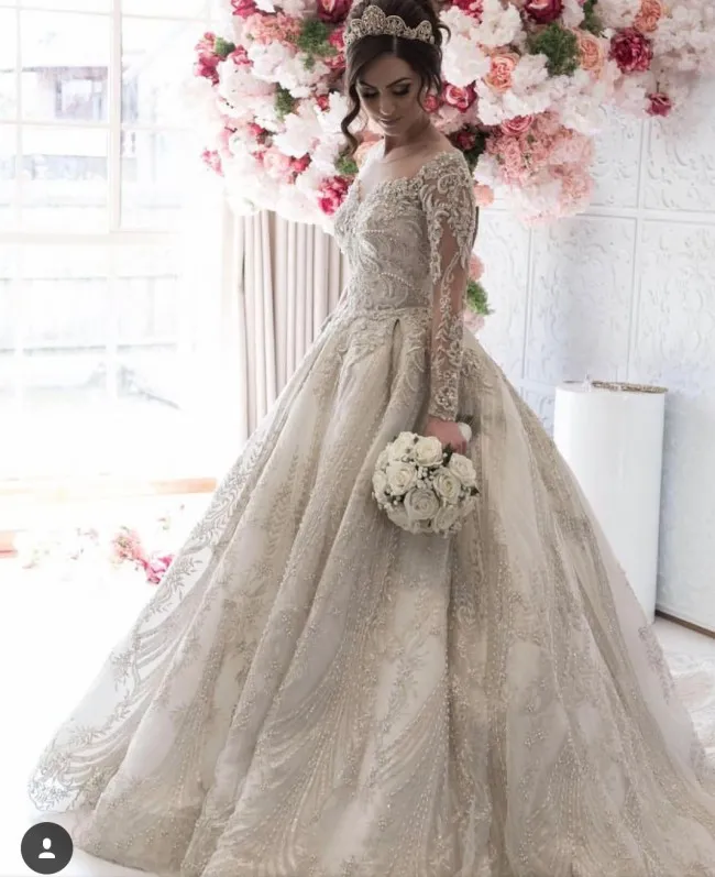 Abito da sposa glamour in pizzo con scollo a barchetta Abito da sposa con collo gioiello trasparente Maniche lunghe Perline con perline Abito da sposa con applique Affascinante abiti da sposa con strascico da cappella