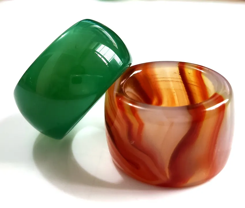 Bonhams : TWO JADEITE AND ONE PALE GREEN AND RUSSET JADE THUMB RINGS Qing  Dynasty (3)