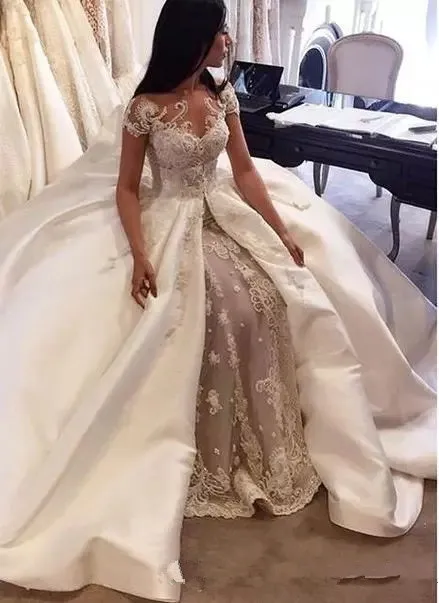 Luksusowe Suknie Balowe Suknie Ślubne Saudyjska Arabia Czapka Rękaw Koronki Aplikacja Satin Overskirt Suknie Ślubne Custom Made Dubai Suknia ślubna