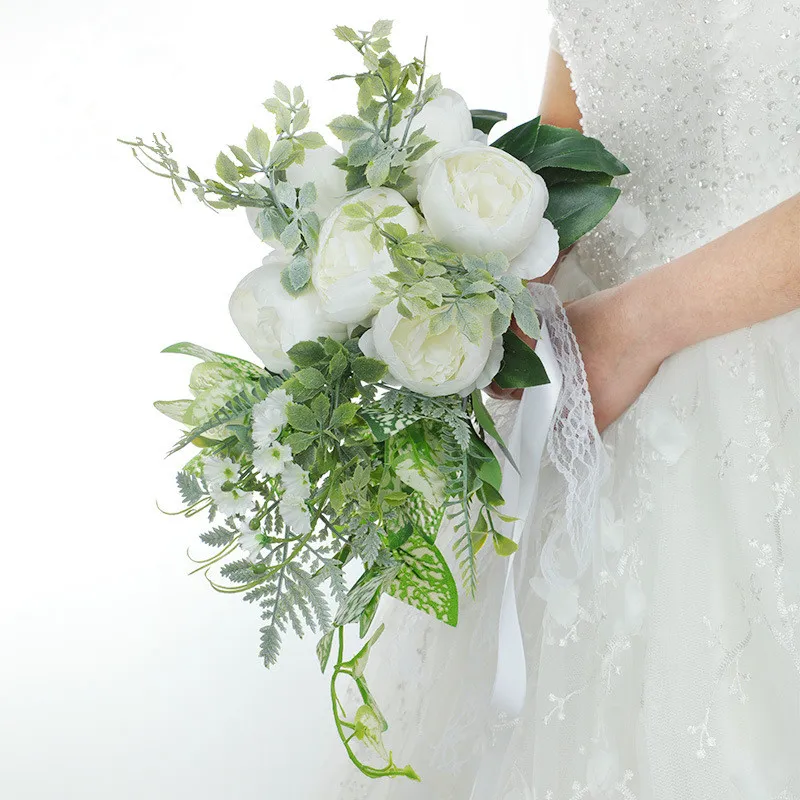 Noiva do casamento do estilo ocidental que guarda flores com buquê artificial da peônia da fita do laço para adereços de tiro da decoração do partido