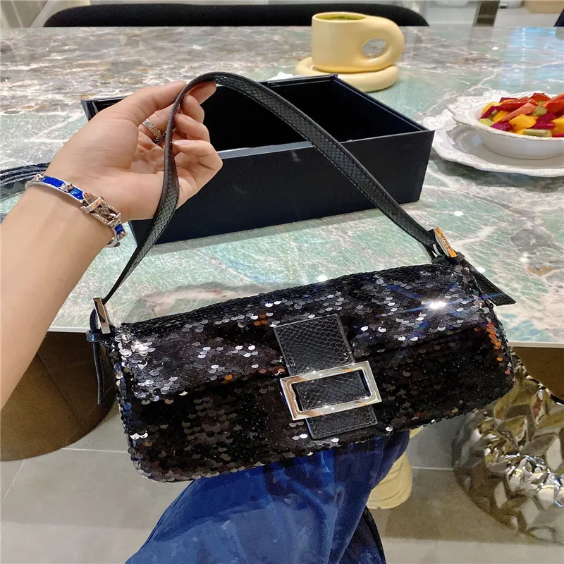 Handbag of shiny black crocodile leather. At the top of the silver-colored  metals (chrome?) Bracket is a semicircular cutting closure that has been  invested with the same leather. The hinged metal