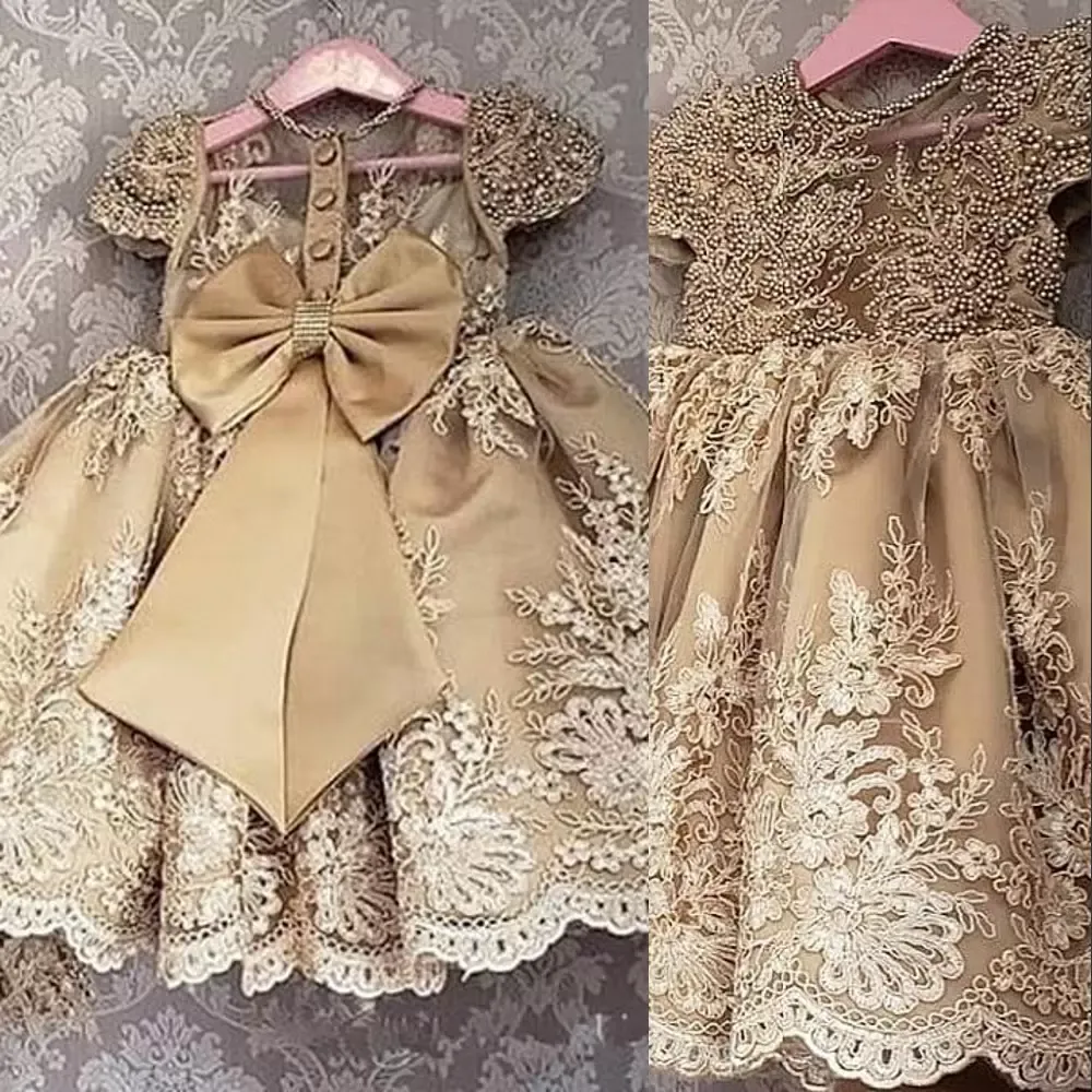 2022 Vestidos de niñas de flores de champán dorado Joya Cuello Mangas de casquillo Apliques de encaje de princesa Perlas de cristal Longitud del piso Arco Vestido de desfile de niña para niños Vestidos de cumpleaños