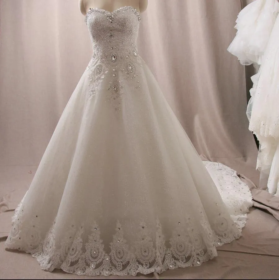 I più nuovi abiti da sposa di lusso Sweetheart Cristalli Swarovski Perline Abito da ballo senza schienale Cappella treno Bling Abiti da sposa avorio personalizzati