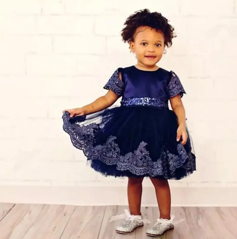 Marineblaue Spitzen-Ballkleid-Blumenmädchenkleider für die Hochzeit, knielange Pailletten-Kommunionkleider mit Ärmeln und großer Schleife am Rücken