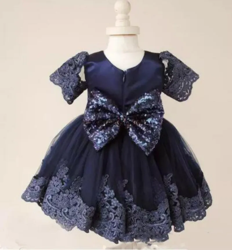 Marineblaue Spitzen-Ballkleid-Blumenmädchenkleider für die Hochzeit, knielange Pailletten-Kommunionkleider mit Ärmeln und großer Schleife am Rücken