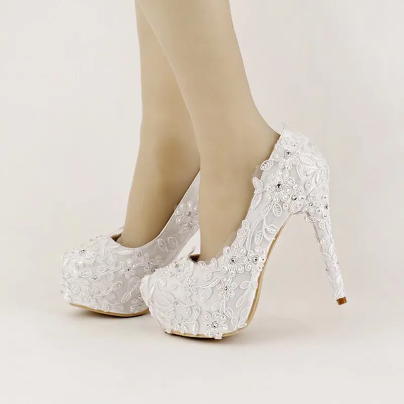 Сладкая белая лента складывает свадебные туфли на высоких каблуках.