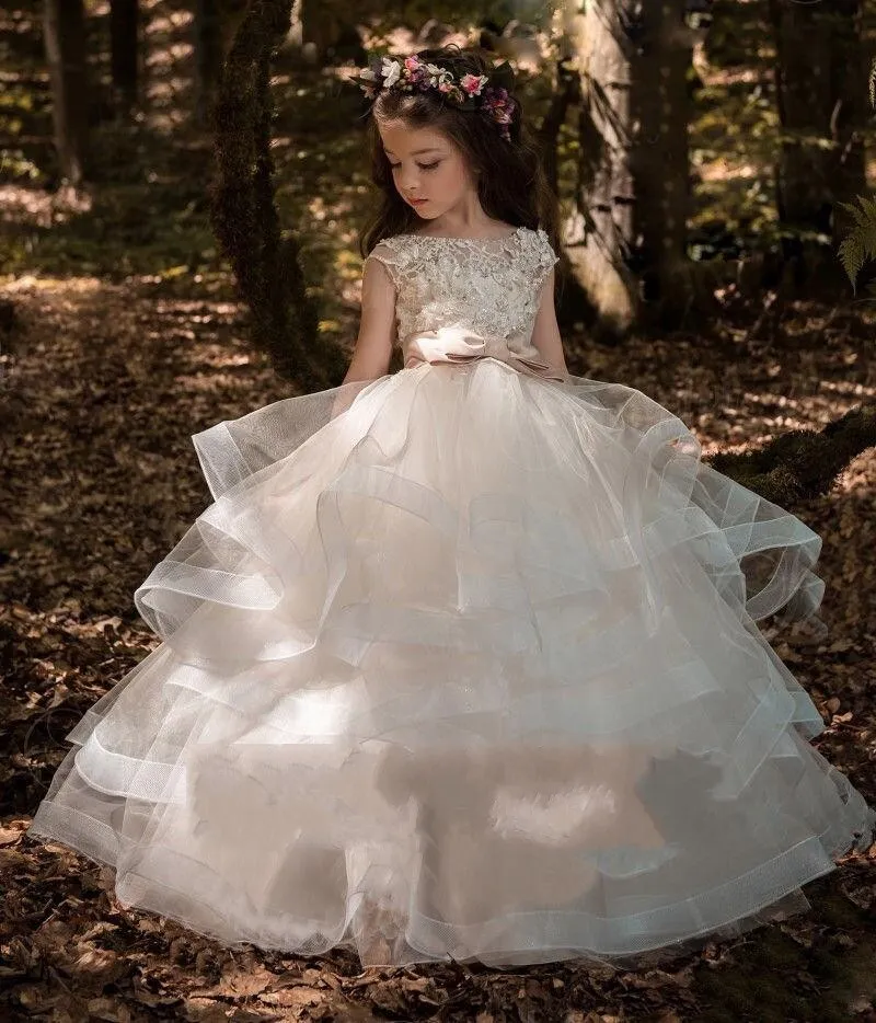 Abito da ragazza di fiori con gonna a strati Abito con retro cavo in pizzo con perline matrimoni Abiti adorabili bambini con fiocco su misura la lunghezza del pavimento