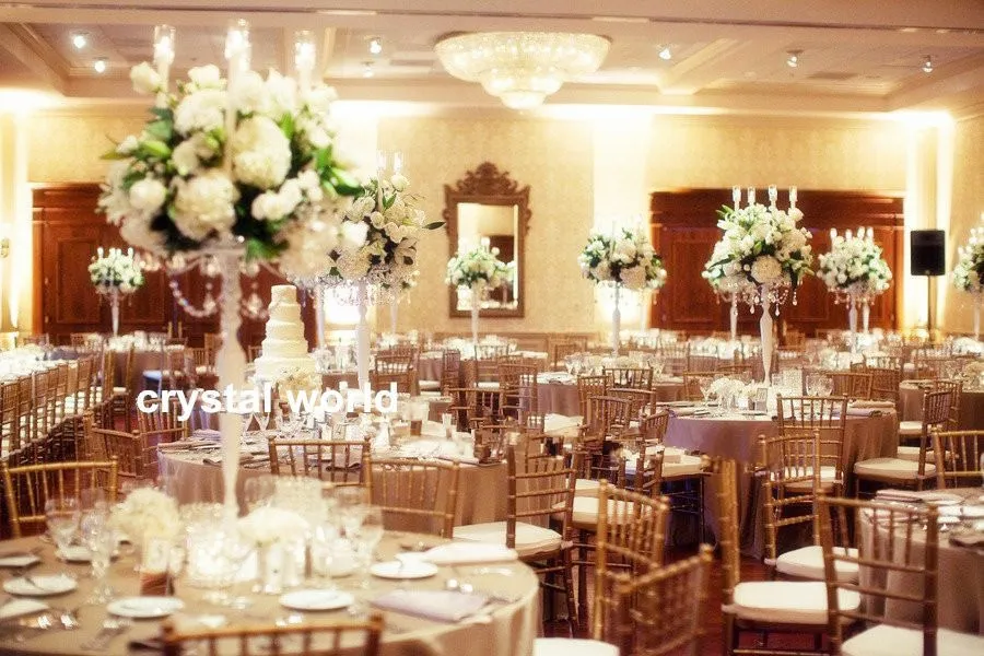 candélabres de mariage blancs sur des centres de table avec suspension en cristal