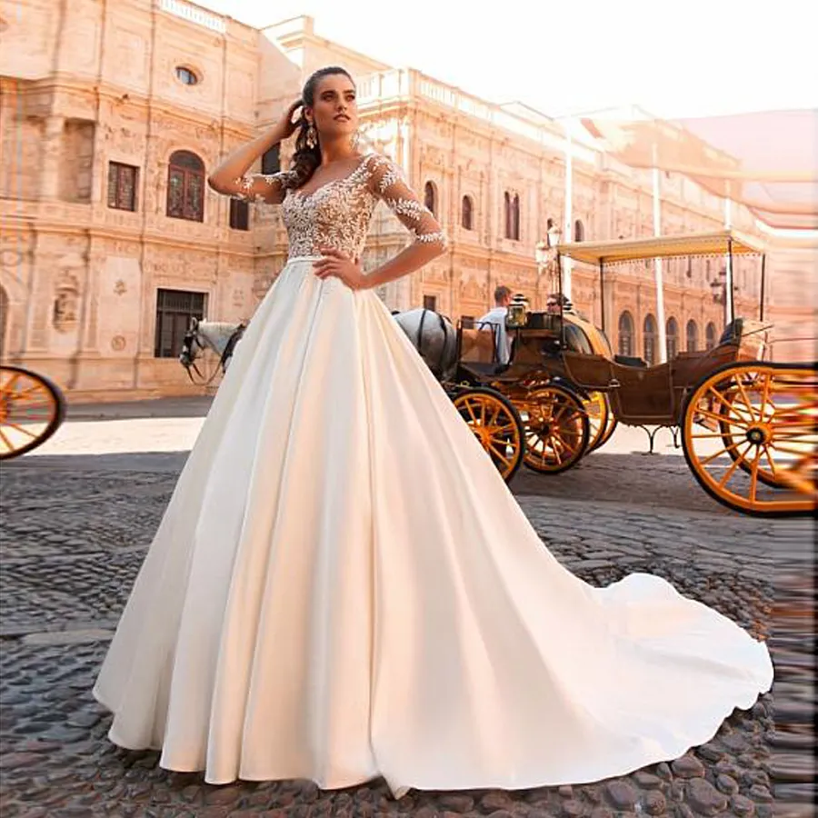 Increíble vestido de novia de una línea transparente con escote barco de satén de tul y apliques de encaje con cuentas Vestido de novia de manga larga transparente