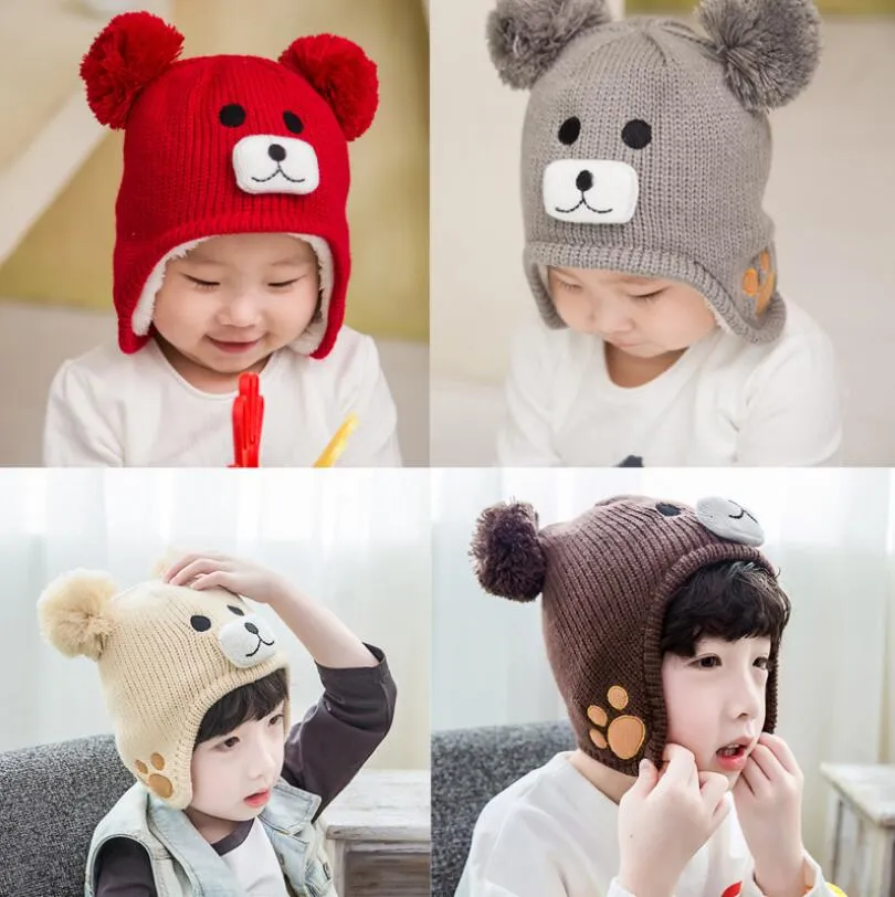 新しい子供の冬の赤ちゃんの帽子漫画のクマの厚い暖かい子供の帽子の女の子の男の子の帽子の帽子二重ボールが付いている男の子の帽子