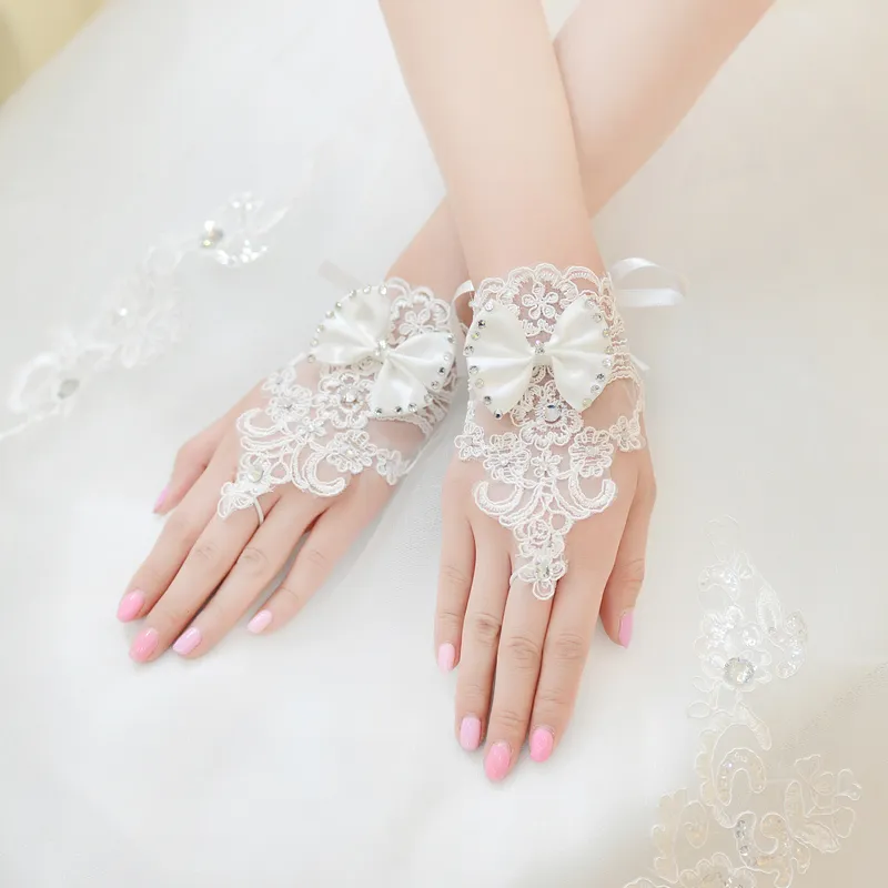 Hochwertige Brauthandschuhe mit echtem Bild, kurze Handgelenklänge, Spitzenapplikation, Strass-Schleifen-Design, Brautaccessoires